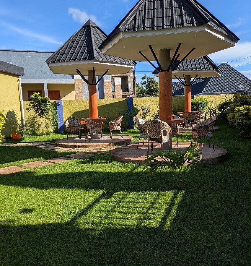 A thatched garden gazebo on the lawn of a safari lodge