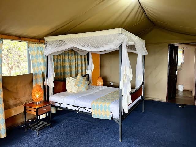 A four-poster bed inside a spacious safari tent