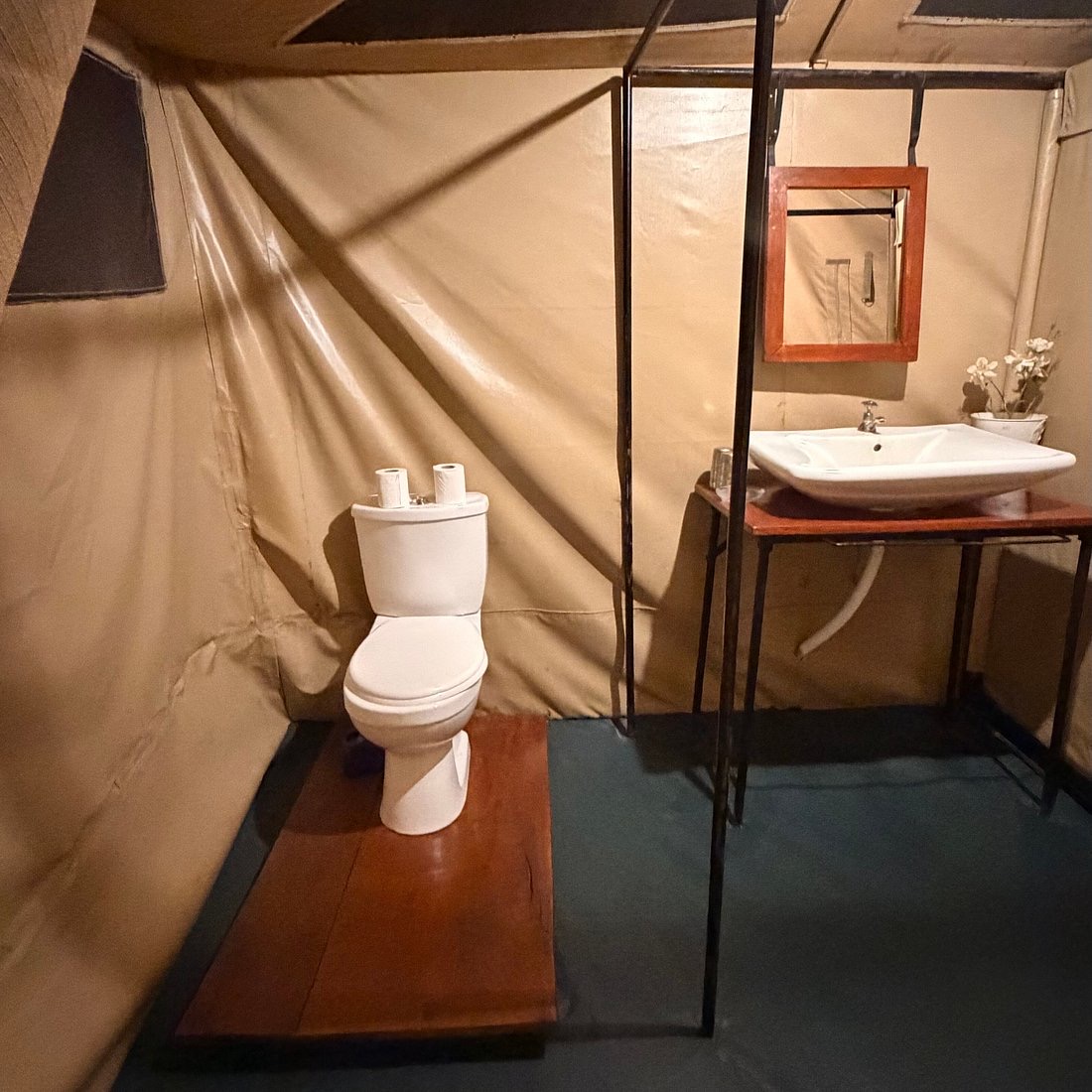 A washbasin and mirror in a safari tent bathroom